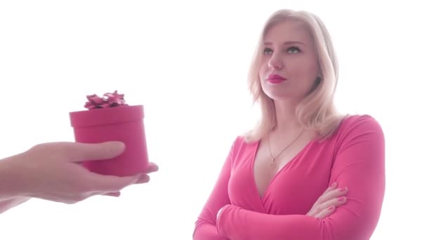 Przytłaczająca blondynka w czerwonej sukience z zanurzonym dekoltem otrzymała prezent od mężczyzn, otwiera prezent i wyrzuca go z niezadowalającą twarzą. Koncepcja złego zachowania — Wideo stockowe