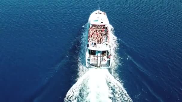 Vista superior de um barco de velocidade navegando no mar azul claro, pessoas dançando a bordo do barco, festa em um iate branco — Vídeo de Stock