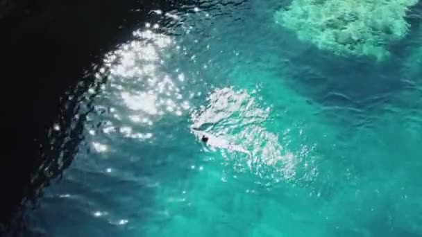 Vista dall'alto sull'uomo che nuota nella limpida acqua blu del mare, estate — Video Stock