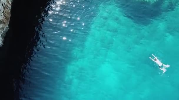 Ovanifrån av det transparenta turkosa havet. Mannen simmar i havet nära klippan, Cypern, hälsosam livsstil — Stockvideo