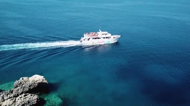 Top uitzicht op een speedboot zeilen in de helderblauwe zee, mensen dansen aan boord van de boot, feest op een wit jacht — Stockvideo