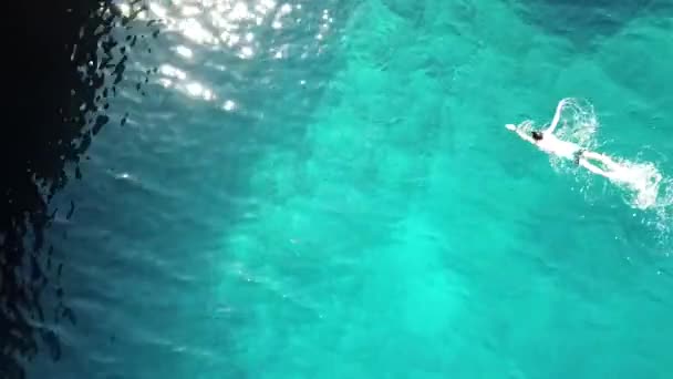 Giovane atletico sta nuotando strisciare nella limpida acqua turchese del mare. la vista dall'alto, stile di vita sano — Video Stock