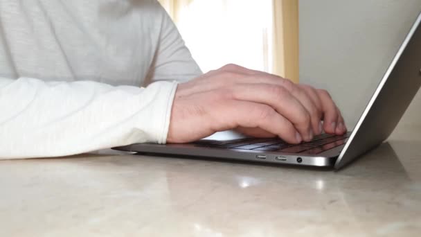 Primer plano de manos masculinas escribiendo algo en la computadora portátil, el concepto de trabajo en la oficina, el hogar, el trabajo remoto, la comunicación en línea — Vídeos de Stock