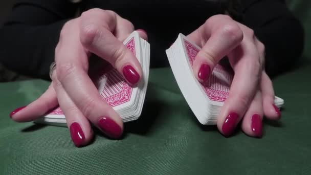 Перетасовка винтовок. Руки женщины с красным лаком для ногтей, тасуют карты. Крупный план, казино, азартные игры — стоковое видео