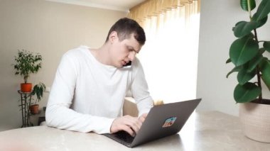 Çoklu görev. Meşgul çekici iş adamı iş konferansı yapıyor, iş yerinde akıllı telefonla konuşuyor dizüstü bilgisayarın önünde oturuyor, düzenleme yapıyor, telefon satışı yapıyor, iş meselelerini tartışıyor.