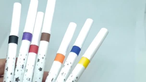 Multi-colored felt-tip pens close-up. Human hands are holding white markers with colorful labels — Stock Video