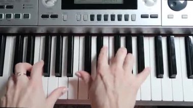Elektronik piyano çalan ellerin üst görüntüsü. Enstrüman çalan virtüöz. Yakın plan.