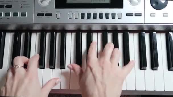 Вид зверху на руки, що грають на електричному піаніно. Віртуоз грає на інструменті. Крупним планом — стокове відео