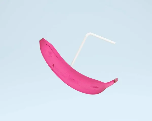 Pink banana z słomki na tle pastel niebieski kolor. minimalne — Zdjęcie stockowe