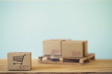 E- ticaret ve çevrimiçi alışveriş kavramı: ikonlu ürünleri paketlemek için karton kutular. Ulaştırma, lojistik, küresel taşımacılık, uluslararası taşımacılık, denizaşırı ticaret, bölgesel, dünya çapında gider