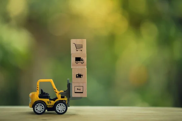 Lojistik ağ dağıtımı ve kargo taşıma konsepti: Mini forklift, ahşap bloklu bir paleti ikon ile hareket ettiriyor. e-ticaret dünyasında mal veya ürün teslimatı tasvir ediyor.