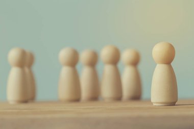 Başarılı iş dünyası lideri konsepti: tahta adam figürleri ve kalabalığın arasında göze çarpan insanlar. İnsan Kaynakları Yönetimi ve işe alım çalışanını veya işe alımını betimler.