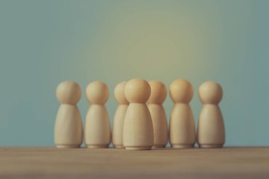 Başarılı iş dünyası lideri konsepti: tahta adam figürleri ve kalabalığın arasında göze çarpan insanlar. Bireyin takipçileri ya da diğer organizasyon üyelerini etkileme ve yönetme becerisini tasvir eder.