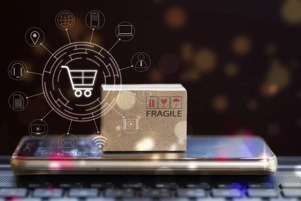 Çevrimiçi alışveriş, e-ticaret konsepti: akıllı telefonlu karton kutu klavye ve ikon müşteri ağı bağlantısı. Üretim hizmeti ve tüketicilere internet üzerinden ulaşım.