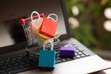 Tramvayda kağıt alışveriş poşetleri ya da klavyede alışveriş arabaları. Müşterilerin evden ya da ofisten her şeyi satın alabileceği ve kuryenin kapı eşiğine getireceği internet alışverişi kavramı.