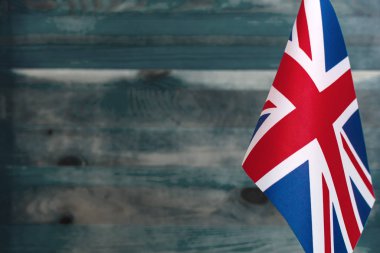 Büyük Britanya bayrağının ön plandaki parçası metnin altındaki ahşap arka planı bulanıklaştırdı.