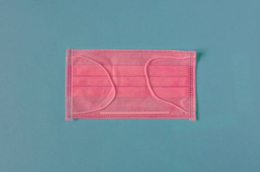 Pembe tıbbi maske, arka planda, yukarıdan yakın plan.