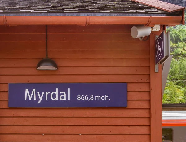 Kırmızı ahşap bir binada istasyonun adı ve deniz seviyesinin yüksekliği yazılı. Myrdal İstasyonu, Norveç.