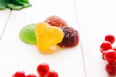 parlak meyve reçeli beyaz tahtalar üzerinde ışık ile sular altında. nane yaprakları parlak kırmızı meyveler sona