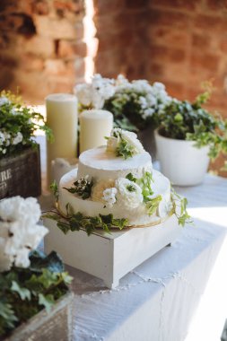 Düğün pastası. Yeşil Beyaz küçük çiçek yaprakları candlesflowers masa dekorasyon düğün kutularında bir masada