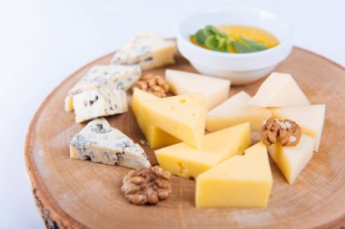 Tahtaya bal sürülmüş peynir tabağı, beyaz arka plan değil.