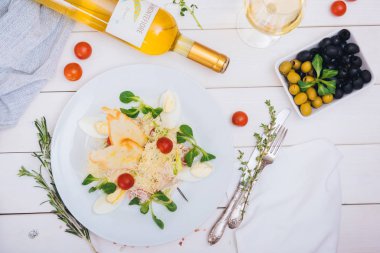 Dekorlu beyaz tahtalı salata ve menü için bir şişe beyaz şarap.