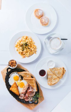 Kahve, yumurta, tost, krep ve reçelli büyük bir kahvaltı. süzme peynirli krep, reçelli cheesecake. Yukarıdan görünüm