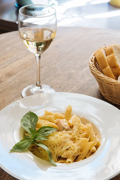 白ワインの隣にチーズとバジルのパパルデッレとレストランで木製のテーブルの上の成分 — ストック写真