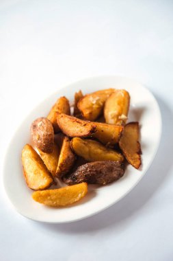 Beyaz tabakta oval tabakta kızarmış patates.