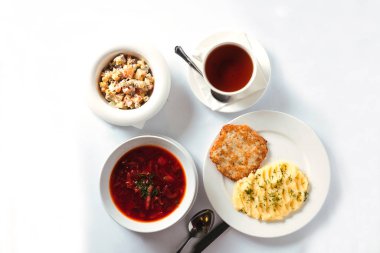 Öğle yemeği püresini pirzola, borş çorbası ve Olivier salatasıyla hazırla. İş yemeği. siyah çay