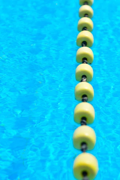Sarı göstergeyi kayan nokta çizgi ile şeffaf su Yüzme Havuzu. Yaz güneşi parlaklığı ile yoğun mavi. Serin banyo almaya hazır