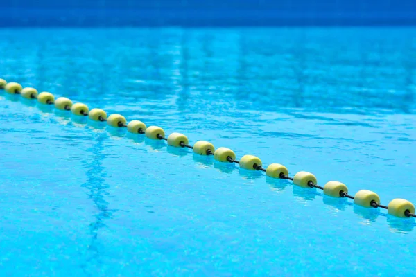 Sarı göstergeyi kayan nokta çizgi ile şeffaf su Yüzme Havuzu. Yaz güneşi parlaklığı ile yoğun mavi. Serin banyo almaya hazır