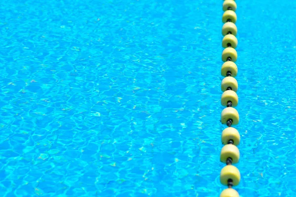 Sarı göstergeyi kayan nokta çizgi ile şeffaf su Yüzme Havuzu. Yaz güneşi parlaklığı ile yoğun mavi. Serin banyo almaya hazır
