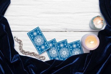 Beyaz masa arkaplanında kopyalama alanı olan mavi tarot kartları.