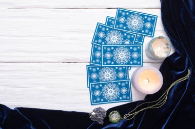 Beyaz masa arkaplanında kopyalama alanı olan mavi tarot kartları.