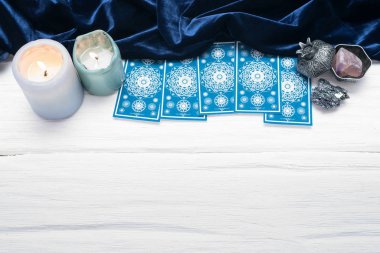 Beyaz masa arkaplanında kopyalama alanı olan mavi tarot kartları.