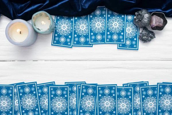 Beyaz masa arkaplanında kopyalama alanı olan mavi tarot kartları.