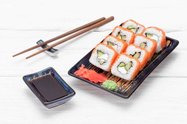 Suşi Philadelphia 'yı beyaz ahşap masa arkasında yuvarlıyor..