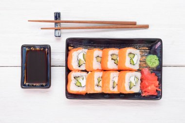 Suşi Philadelphia 'yı beyaz ahşap masa arkasında yuvarlıyor..