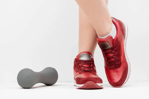 Pernas Femininas Sapatos Esportivos Vermelhos Haltere Chão Branco Perto — Fotografia de Stock