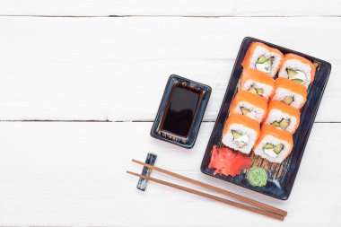 Suşi Philadelphia 'yı beyaz ahşap masa arkasında yuvarlıyor..