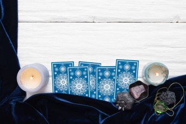 Beyaz masa arkaplanında kopyalama alanı olan mavi tarot kartları.