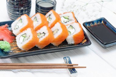 Suşi Philadelphia 'yı beyaz ahşap masa arkasında yuvarlıyor..