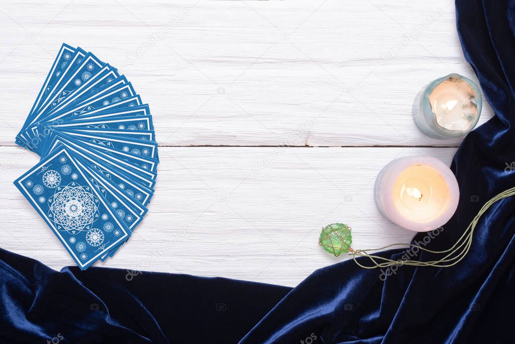Blue tarot cards on white wooden table background with copy space.