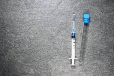 Siyah zemin üzerinde şırınga ve boş matara kopyalama alanı.