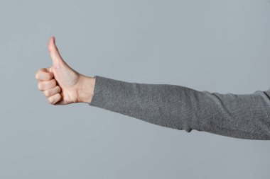 Gri arka planda izole edilmiş kadın ellerinin işareti..