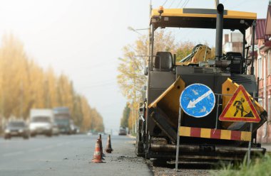 Yol onarımı konsepti. Asfalt yol arka planında yol silindiri.