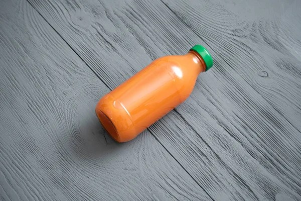 Karottensaft Einer Flasche Auf Grauem Tischhintergrund — Stockfoto