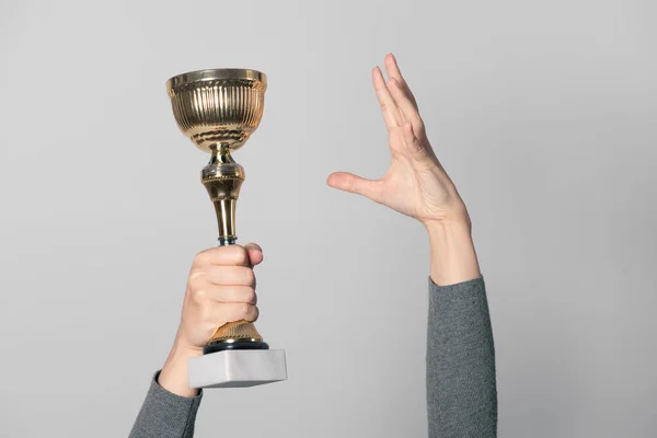 Goldener Siegerpokal Der Hand Isoliert Auf Grauem Hintergrund Preisverleihung — Stockfoto