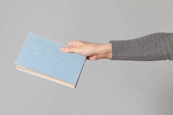 Χέρι Κρατώντας Ένα Βιβλίο Απομονωμένο Γκρι Φόντο — Φωτογραφία Αρχείου